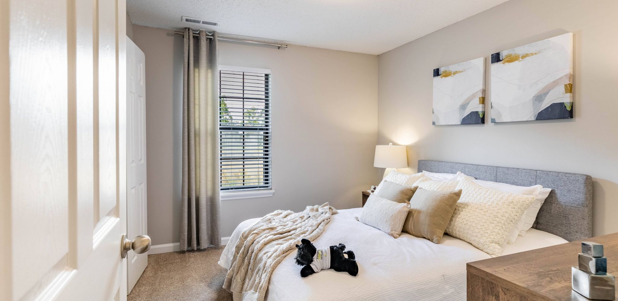 Hawthorne at the Ridge apartment bedroom with carpet, ceiling fan, bedside tables, and bed