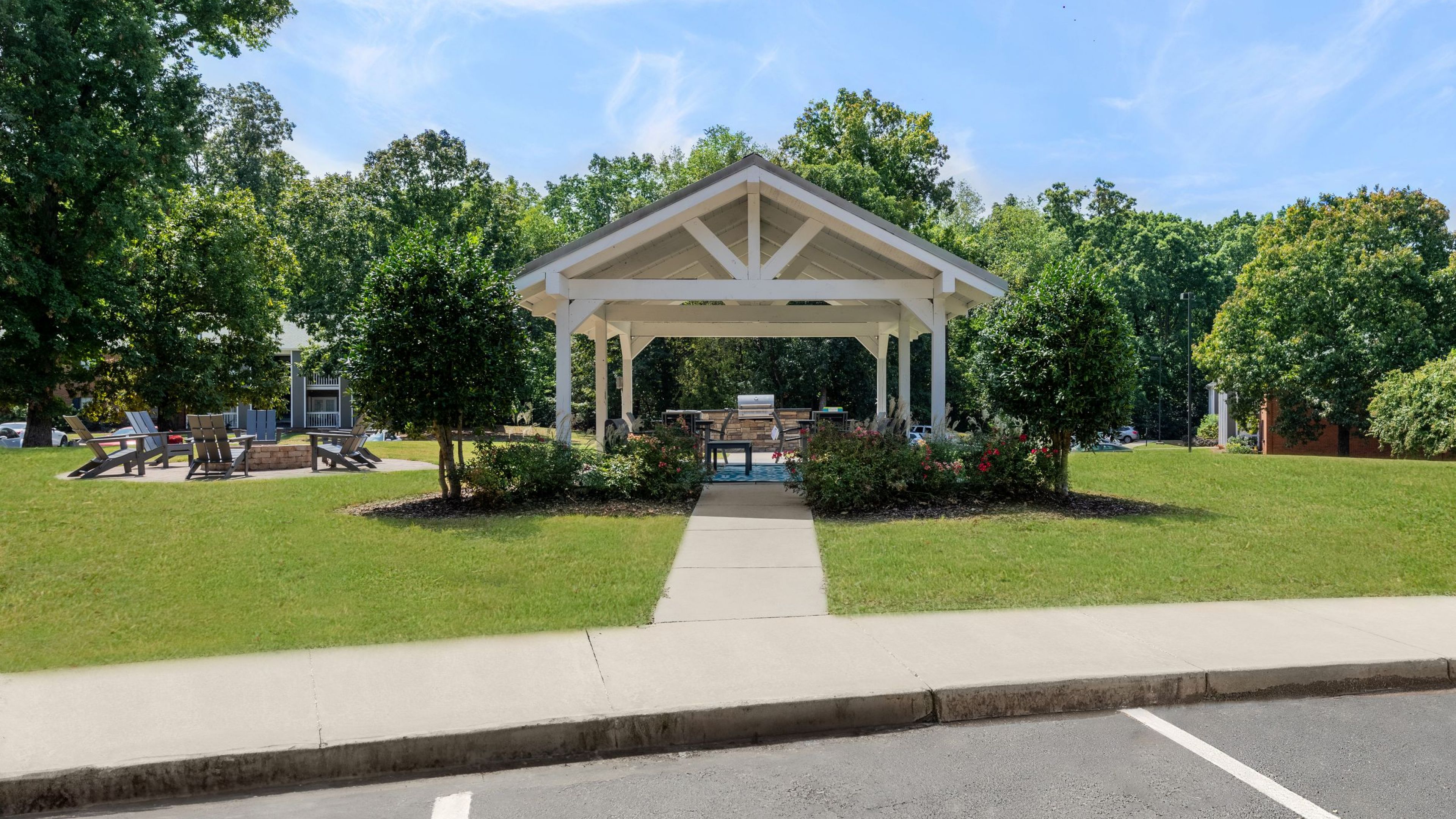 Hawthorne at the Ridge outdoor picnic area with tables and grilling, surrounded by beautiful trees and a green lawn