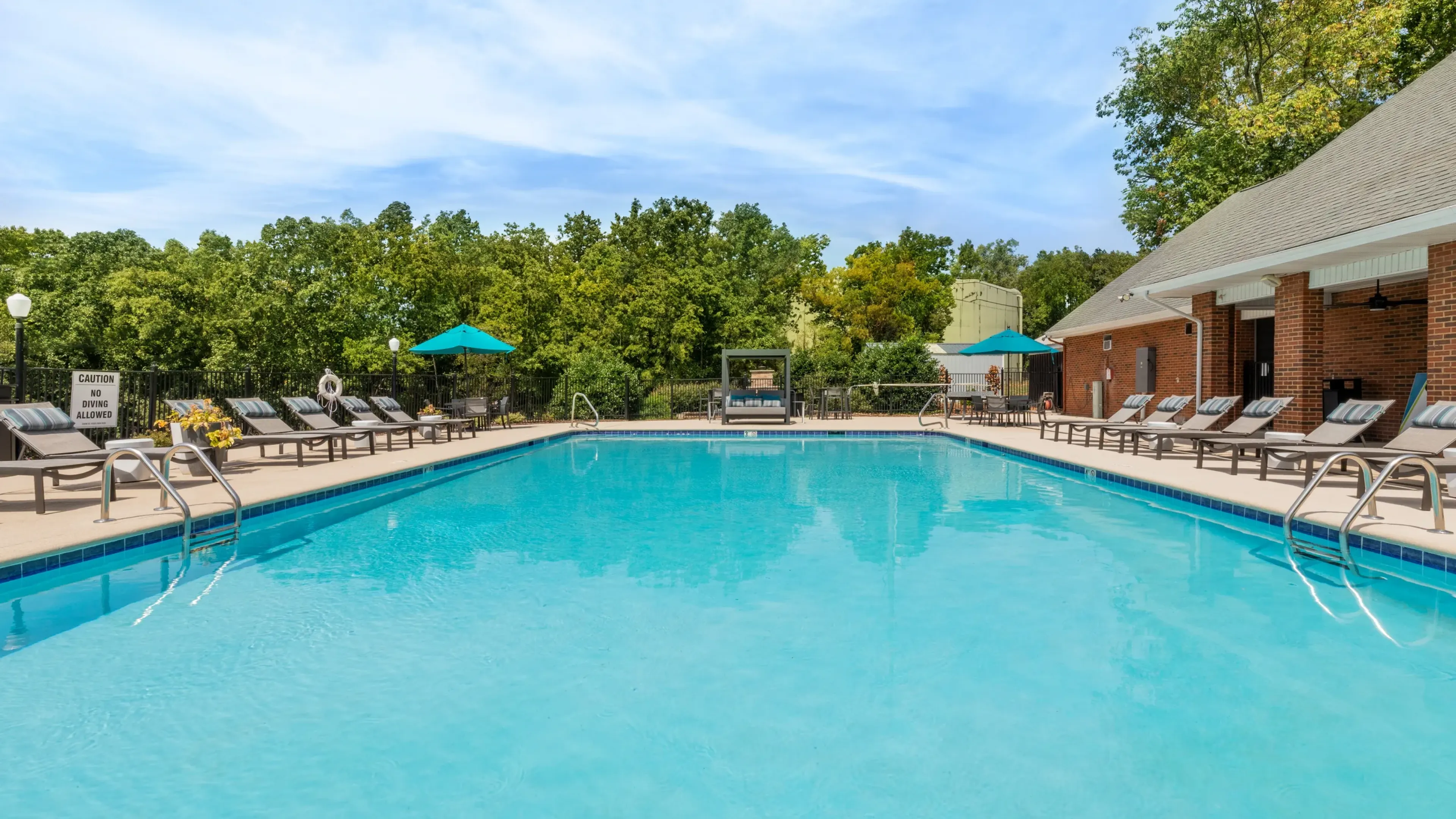 Hawthorne at the Ridge large outdoor pool with lounge chairs, surrounded by green trees
